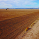 Farmers ride their horses next to a fence that adjoins a drought-affected paddock, in central New South Wales in July of 2018.